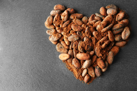 Heart made of aromatic cocoa beans on grey backgroundの写真素材