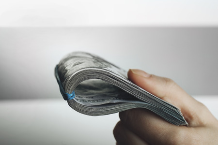 Hand holds money on grey background, close upの写真素材