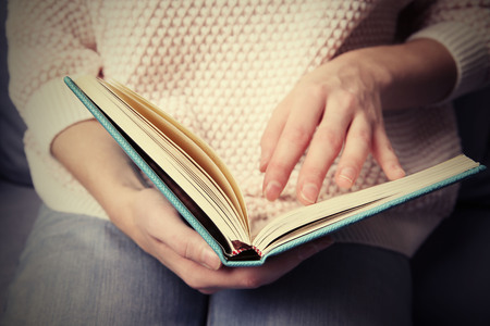 Woman  reading book at home, close upの写真素材