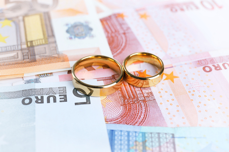 Golden wedding rings on euro banknotes background. Marriage of convenienceの写真素材