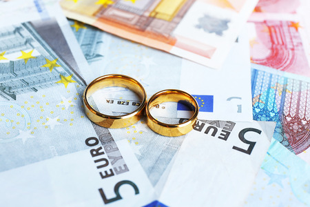 Golden wedding rings on euro banknotes background. Marriage of convenienceの写真素材