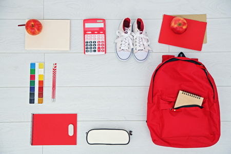 School set with backpack, shoes and supplies on light wooden backgroundの写真素材
