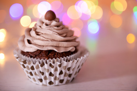 Tasty chocolate cupcake with butter cream on a glitter background, close upの写真素材
