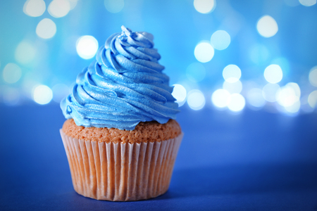 Cupcake with blue cream icing on a glitter background, close upの写真素材