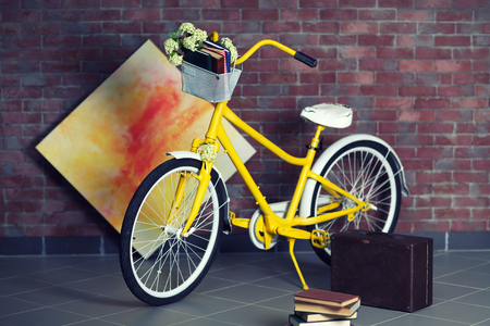 Yellow bicycle with books on brick wall backgroundの写真素材