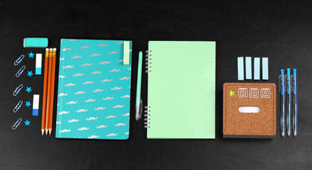 School supplies near blackboard, close up