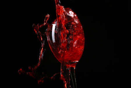 Wine pouring in glass on black background