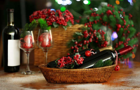 Wine in wicker bowl and Christmas decor on tableの写真素材