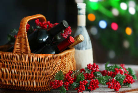 Wine in basket on blurred Christmas tree background