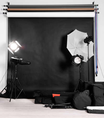 Empty photo studio with lighting equipment,  bags and backdropの写真素材