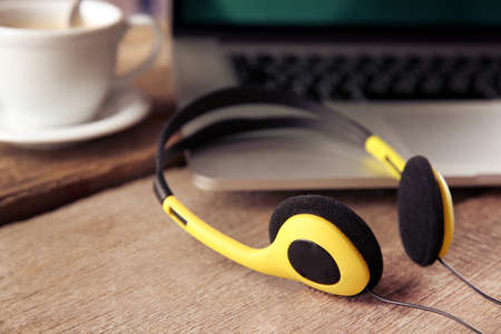 Laptop and earphones on wooden backgroundの写真素材