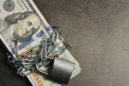 Dollars currency with lock and chain on grey backgroundの写真素材