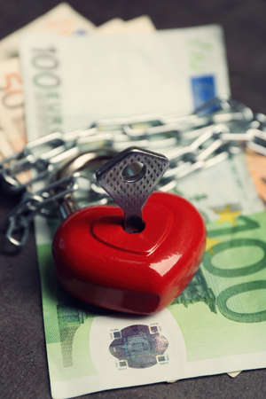 Euro banknotes, chain and lock in shape of heart, close upの写真素材