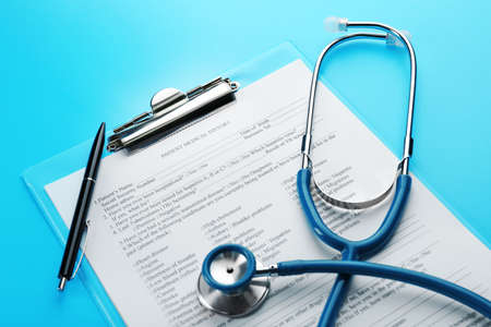 Medical stethoscope, clipboard and pen, on blue backgroundの写真素材