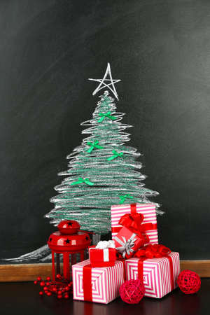 Fir tree drawing on blackboard and beautiful gifts. Xmas backgroundの写真素材
