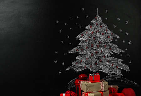 Fir tree drawing on blackboard and beautiful gifts. Xmas backgroundの写真素材