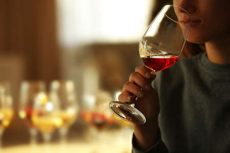 Woman sniffing red wine in a glass, close up