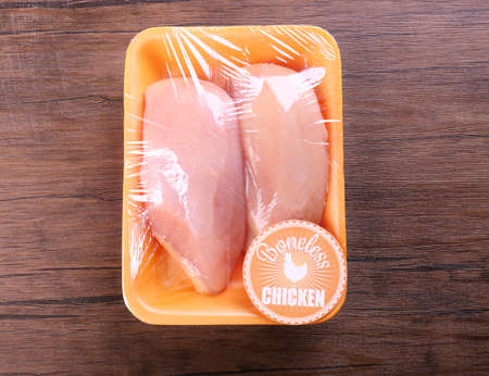 Packed pieces of chicken meat on wooden backgroundの写真素材