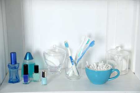 Bathroom set with toothbrushes and sponges on a shelf in light interiorの写真素材