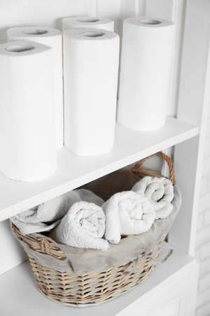 Bathroom set with towels and basket on a shelf in light interiorの写真素材