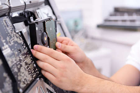 Young repairer disassembling a computer internal parts in service centerの写真素材