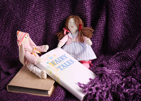 Rag dolls with fairy tales books on bedspread. Childhood conceptの写真素材