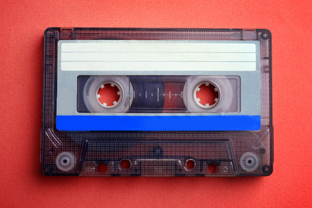 Old audio cassette on red background