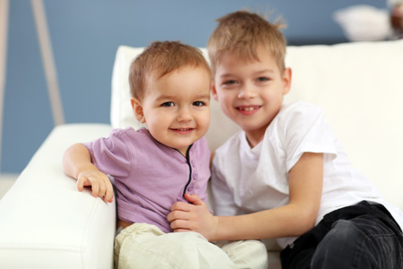 Portrait of cute cheerful brothers in the roomの写真素材