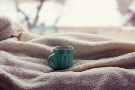 Cup of tea and warm blanket on windowsill, close upの写真素材