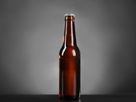Glass bottle of dark beer on grey backgroundの写真素材