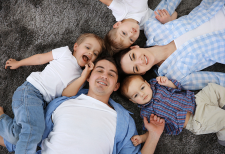 Family concept. Happy family head to head lying on the floorの写真素材