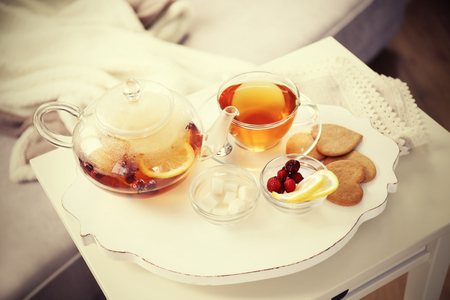 Tea set with hot tea and breakfast on a white wooden mat on the tableの写真素材