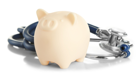 Piggy bank with stethoscope isolated on whiteの写真素材