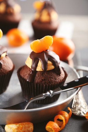 Tasty cupcakes with slice of mandarin and chocolate in a pan, close upの写真素材