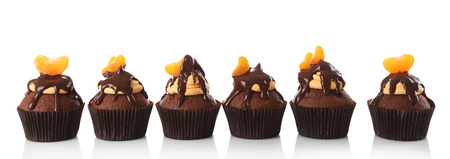 Tasty cupcakes with slice of mandarin and chocolate, isolated on whiteの写真素材