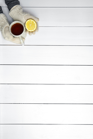 Female hands holding cup of hot drink, on wooden table backgroundの写真素材