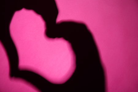 Hand shaped heart on lilac backgroundの写真素材