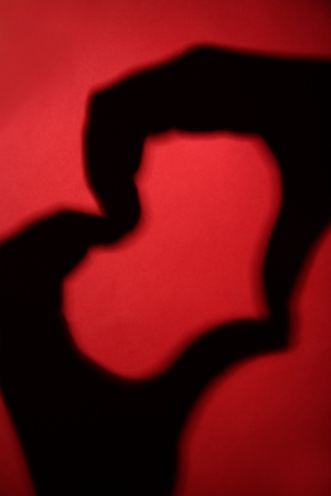 Hand shaped heart on red background