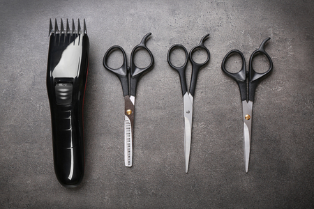 Barber set with hair trimmer and scissors on grey backgroundの写真素材