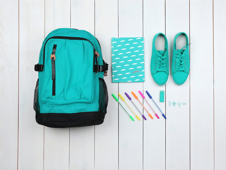 Backpack and school supplies on wooden background, close up. Top view.の写真素材