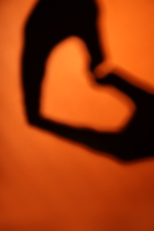 Hand shaped heart on orange background