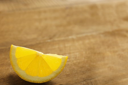 Slice of fresh lemon on wooden backgroundの写真素材
