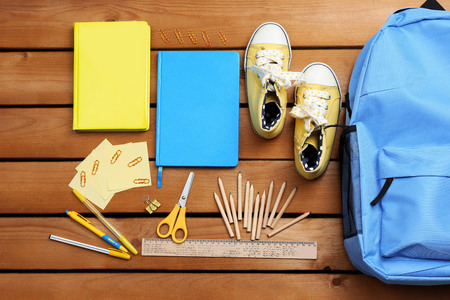 School set with backpack, shoes and supplies on wooden backgroundの写真素材