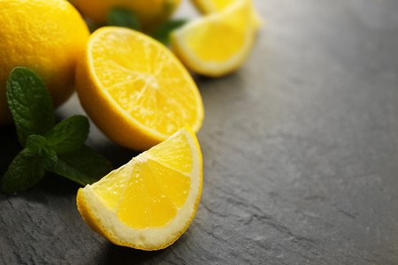 Slices of fresh lemon with green leaves on table closeupの写真素材