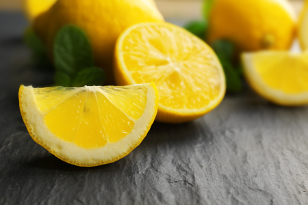 Slices of fresh lemon with green leaves on table closeupの写真素材