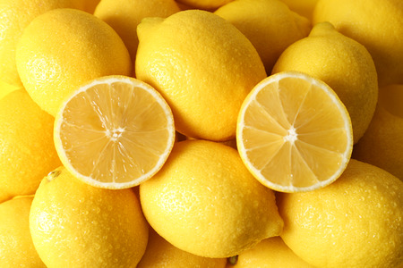 Pile of wet lemons with halves closeupの写真素材