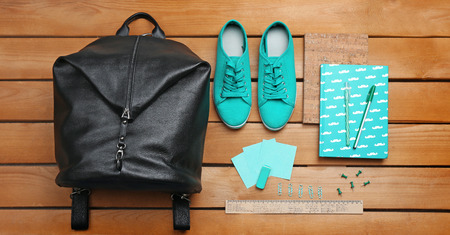 School set with backpack, shoes and supplies on wooden backgroundの写真素材