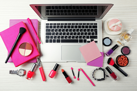 Laptop with woman's accessories on white wooden table backgroundの写真素材