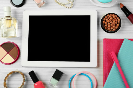 Digital tablet with woman's accessories on white wooden table background, top viewの写真素材