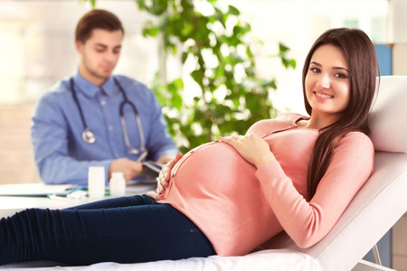 Pregnant woman with doctor at hospitalの写真素材